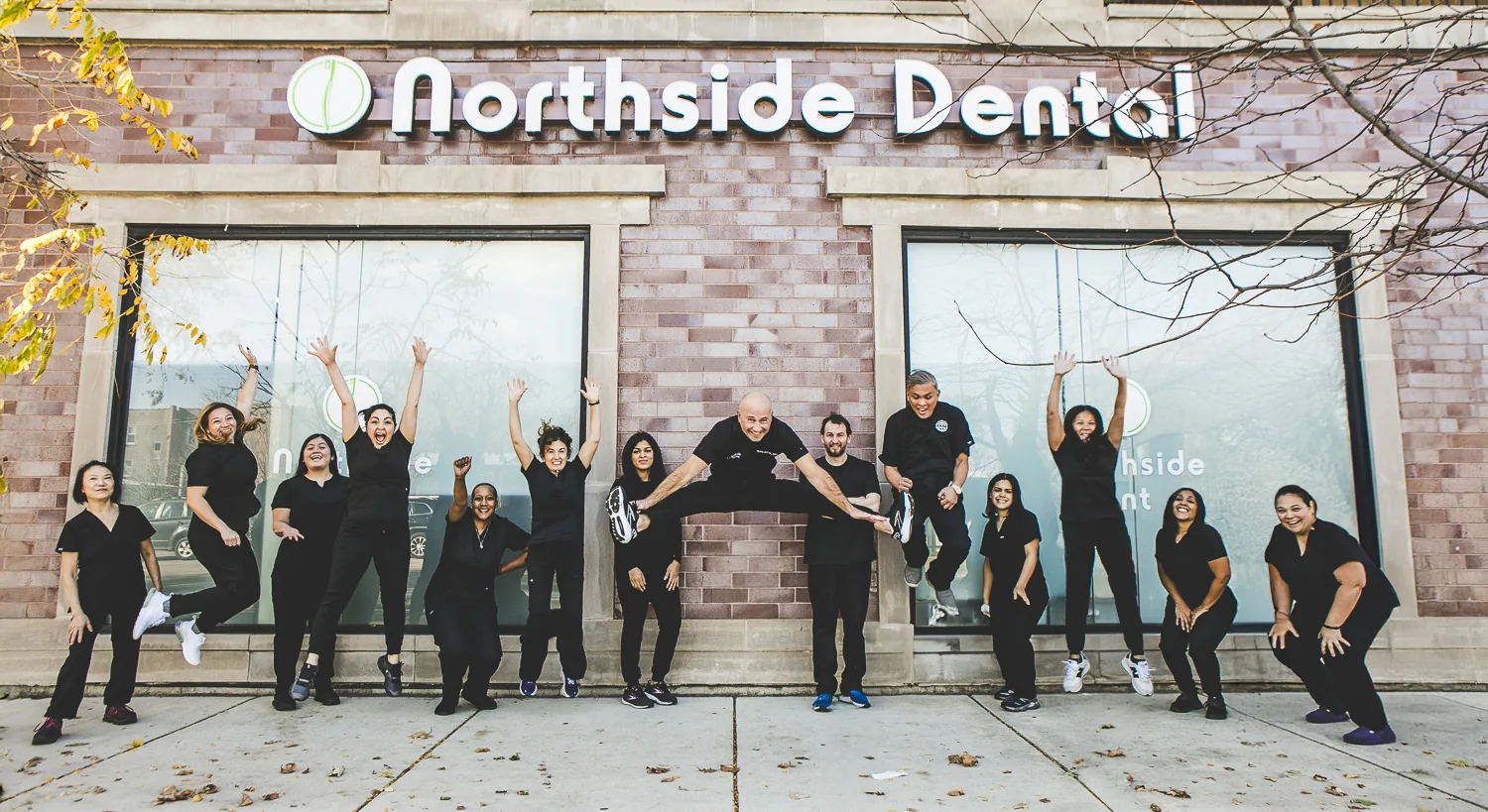 The Northside Dental team leaping outside the office on Clark Street